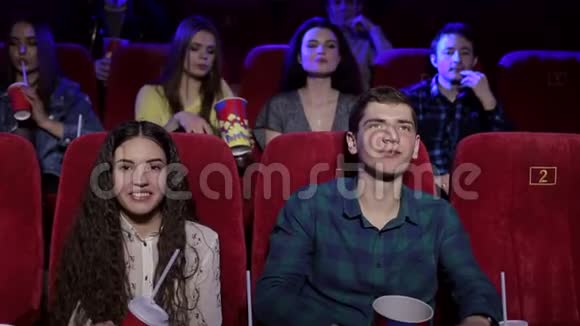一对快乐的年轻夫妇在电影院里扔爆米花视频的预览图
