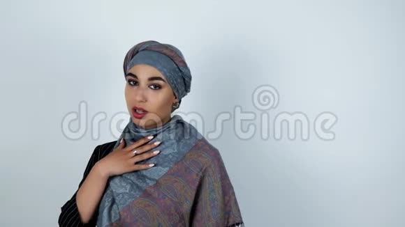 年轻美丽的阿拉伯女人滑下她的手在孤立的白色背景上移动视频的预览图