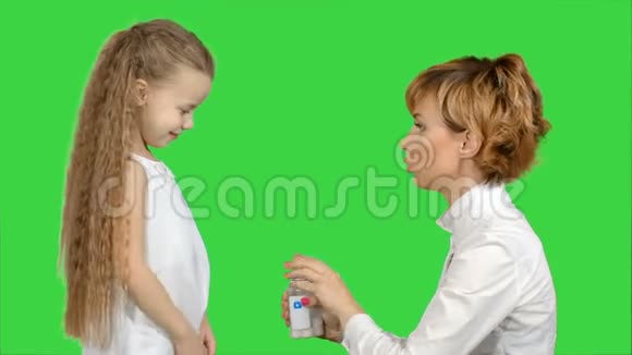 母亲在绿色屏幕上给女儿吃药Chroma键视频的预览图