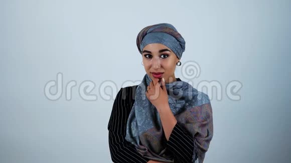 年轻美丽的阿拉伯女人微笑着抚摸着她的下巴她的手在孤立的白色背景上移动视频的预览图