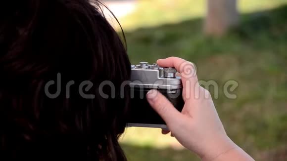 黑色头发的女人用旧相机拍照视频的预览图