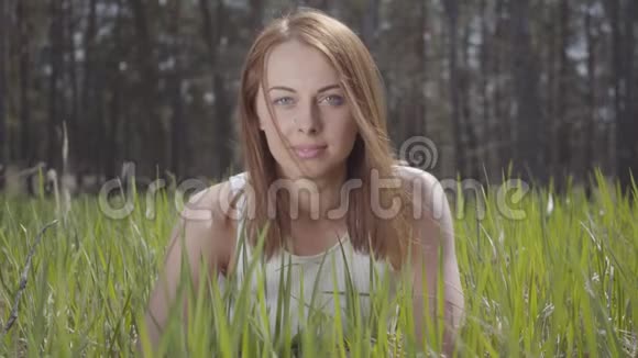 一幅美丽可爱的少女在绿草如茵的森林中的画像视频的预览图