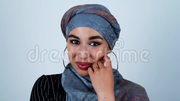 年轻美丽的阿拉伯女人微笑着她的手靠近她的脸在孤立的白色背景下感到高兴视频的预览图