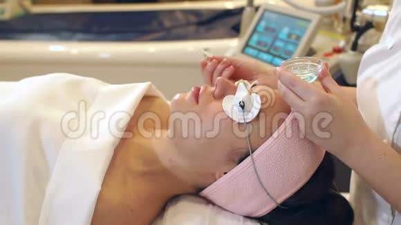 一名妇女在水疗中心接受清洁和提升面部皮肤的程序视频的预览图