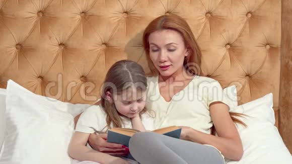 有魅力的女人喜欢和她可爱的小女儿一起看书视频的预览图