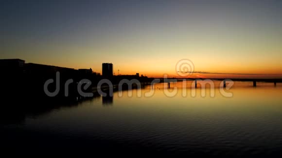 日落时在宽阔的河流上鸟瞰大桥夕阳映在water4kCopy的空间里视频的预览图