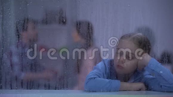心烦意乱的女孩坐在雨窗后听父母吵架有问题视频的预览图