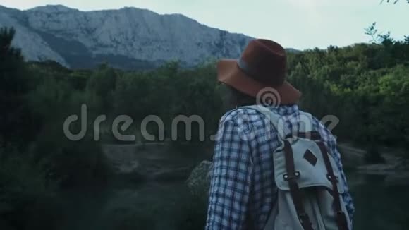 一个年轻人在山林中徒步旅行积极的生活方式穿着格子衬衫和旅行者视频的预览图