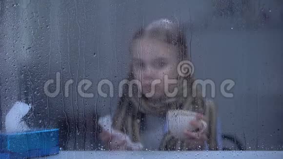 小女孩患了流感躲在雨窗后打喷嚏喝热茶视频的预览图