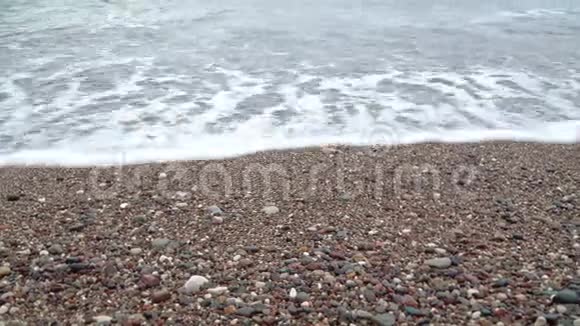 海浪与泡沫冲刷卵石海滩视频的预览图