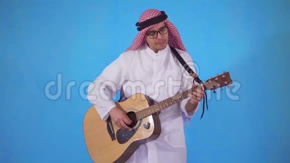 阿拉伯男人笨拙地在蓝色背景下弹吉他视频的预览图
