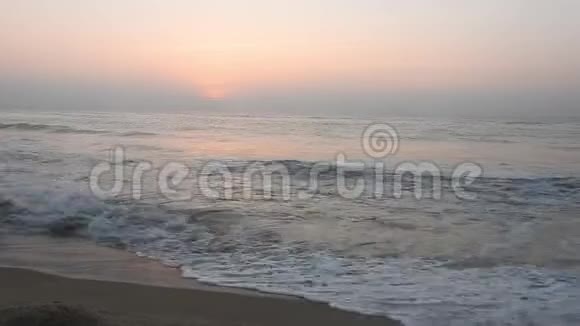 海面上一片平静安详的黎明沙滩上的小波浪翻滚两只海鸥飞向天边大太阳和太阳视频的预览图