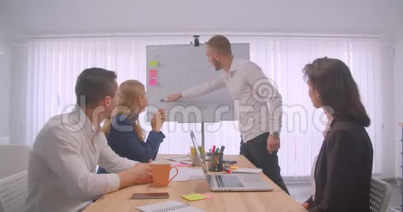四个欢快的拼贴画在办公室室内开会商人在白板上画一张图表视频的预览图