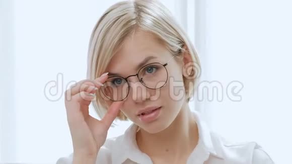 年轻漂亮的金发女郎戴着白色背景眼镜的短发又聪明又优雅喜欢视频的预览图