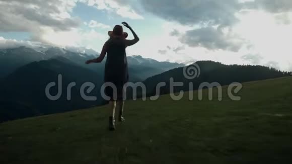 镜头跟随着时髦的千禧年少女身穿一件长裙迎风飘扬登上山顶视频的预览图