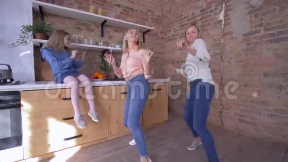 家庭聚会快乐的母亲带着女儿跳舞快乐地呆在家里厨房视频的预览图