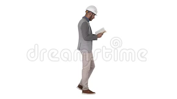 年轻建筑师在白色背景上行走时阅读教科书或笔记本视频的预览图