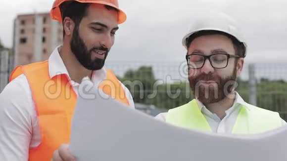 在建筑工地或高层建筑工地与建筑师微笑男建筑工程师讨论视频的预览图