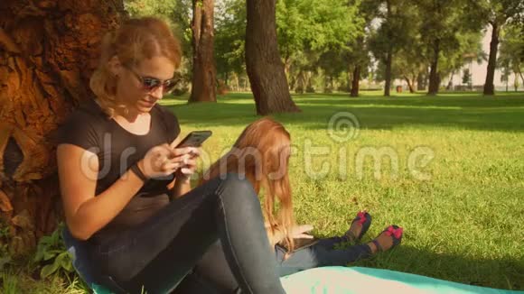 母亲和女儿在公园里使用小玩意视频的预览图