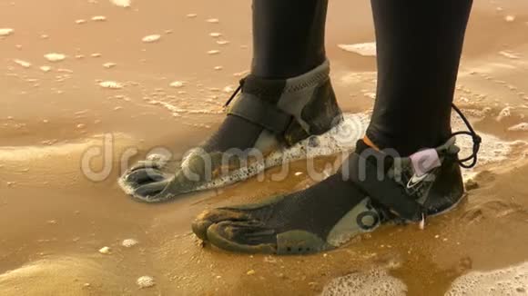 潜水员黑色潜水衣的脚在潮湿的沙子里视频的预览图