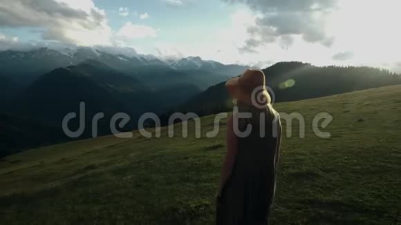 镜头跟随着时髦的千禧年少女身穿一件长裙迎风飘扬登上山顶视频的预览图