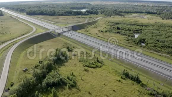 一条靠近绿茵场和湖泊的高速公路的空中摄影视频的预览图