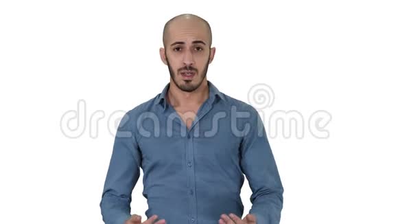 穿着衬衫的阿拉伯年轻人说话展示一些东西并指向白色背景的侧面视频的预览图