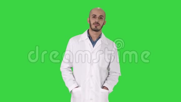 阿拉伯英俊的医生穿着制服双手插在绿色屏幕上的口袋里Chroma键视频的预览图