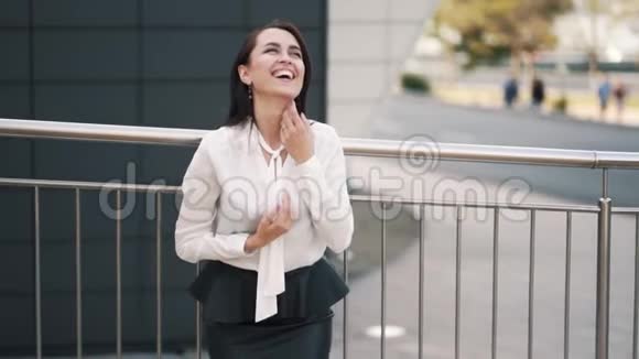 美丽的快乐女孩穿着白色上衣黑色裙子摆在相机上慢动作视频的预览图
