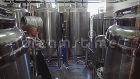 年轻人在小型啤酒厂工作检查啤酒的质量在啤酒厂工作的男性视频的预览图