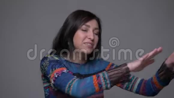 成人白种人深色头发女性舞蹈的特写镜头在镜头前与背景一起享受乐趣视频的预览图