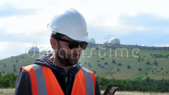 男工程师或建筑工人戴着白色头盔打电话打电话在几个视频的预览图