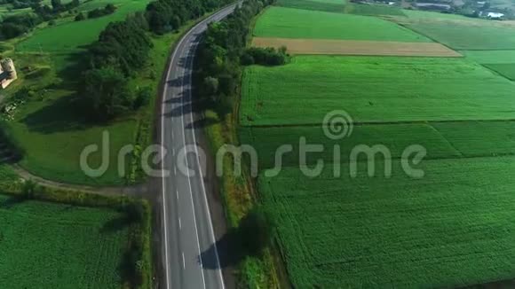 在绿色森林植物之间的道路上乘坐汽车的鸟瞰4K视频的预览图