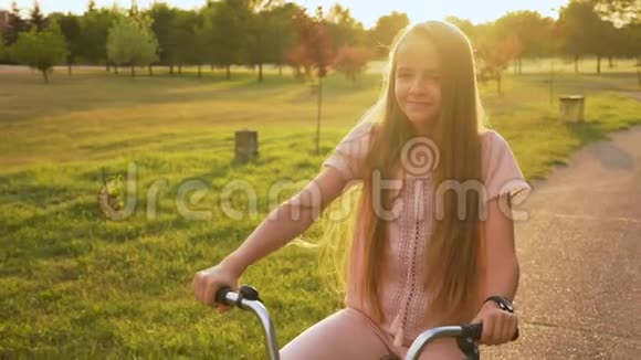 女孩骑自行车在公园小巷关闭视频的预览图