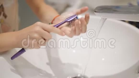 女孩用牙刷清洗水槽里的牙套视频的预览图