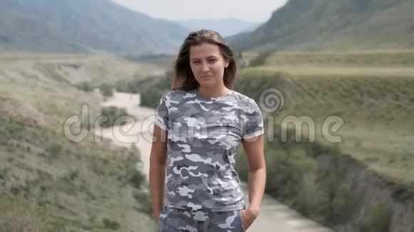 一位美丽的女游客在群山和河流背景下的肖像视频的预览图