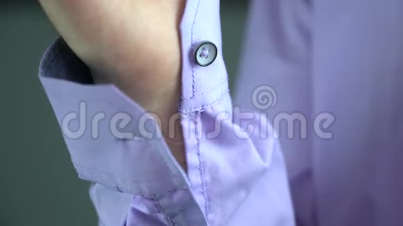 一个男人把扣子扣在袖口上视频的预览图