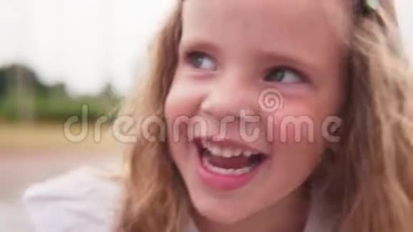 带着幸福的眼睛笑着的小女孩的脸视频的预览图