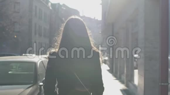 成功的女人慢慢地走在街上明亮的阳光照亮了她视频的预览图