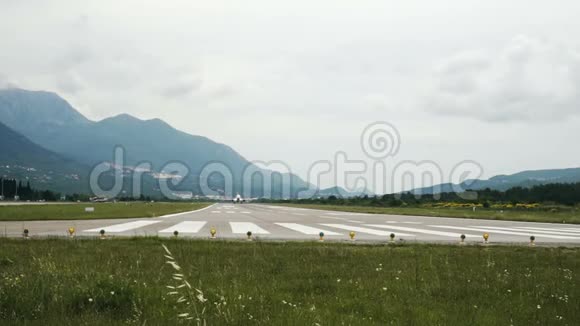 商用飞机从黑山山脉背景的跑道起飞视频的预览图