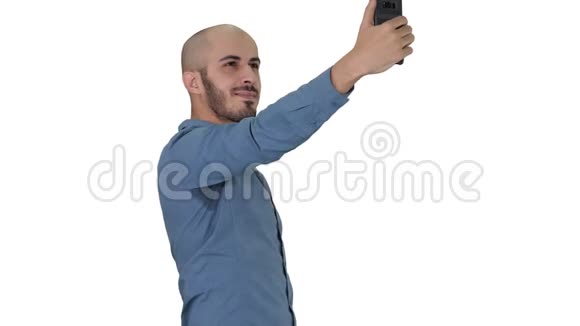 自拍时间英俊的年轻人在白色背景上用手机自拍视频的预览图