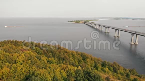 一座连接河流的桥梁横渡河流的驳船前景的绿色区域视频的预览图