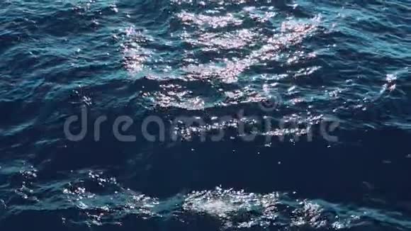 在水面上阳光明媚的蓝色海浪缓慢地移动真正的水波纹关闭液态纹理表面背景视频的预览图