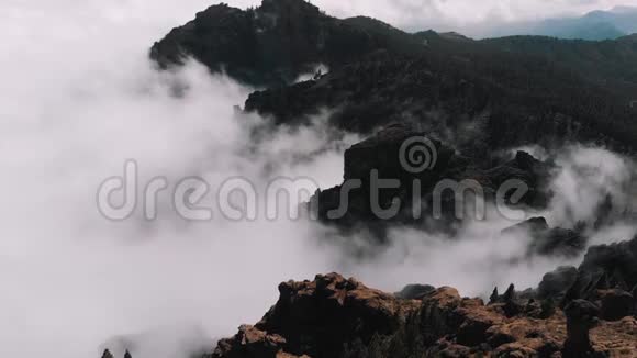 空中景色美丽的云层在群山的峡谷中卷曲从火山谷的高空俯瞰视频的预览图