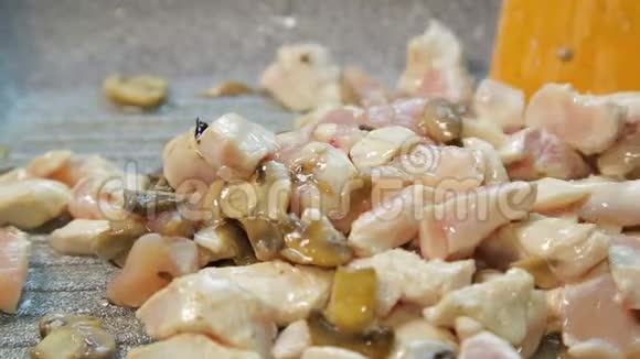 油中的鸡片用木铲混合在平底锅中视频的预览图