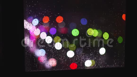 城市生活的灯光和水滴在夜晚的玻璃上反射视频的预览图