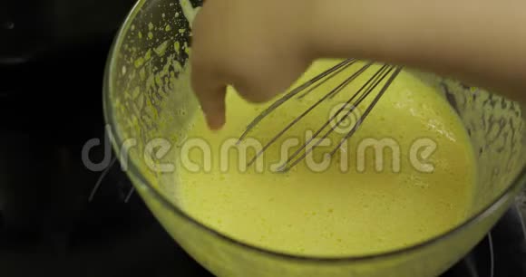 幼儿用一只手指将生鸡蛋和糖放在玻璃碗里视频的预览图