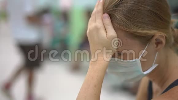 生病的年轻女子坐在医院等待医生预约视频的预览图