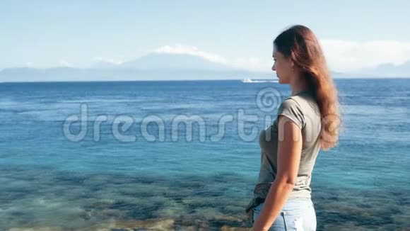 女旅行者用电话接电话慢动作海洋背景山脉视频的预览图