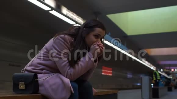 沮丧的孤独女孩哭泣坐在地下分手迷失在大城市视频的预览图